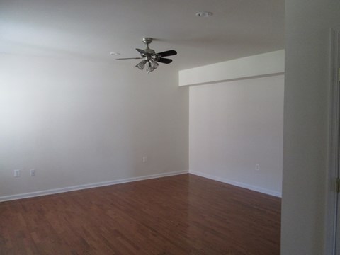 an empty room with white walls and a ceiling fan