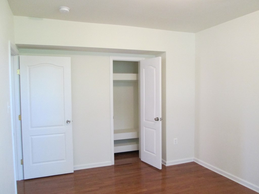an empty room with two doors and a closet
