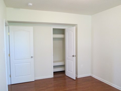 an empty room with two doors and a closet