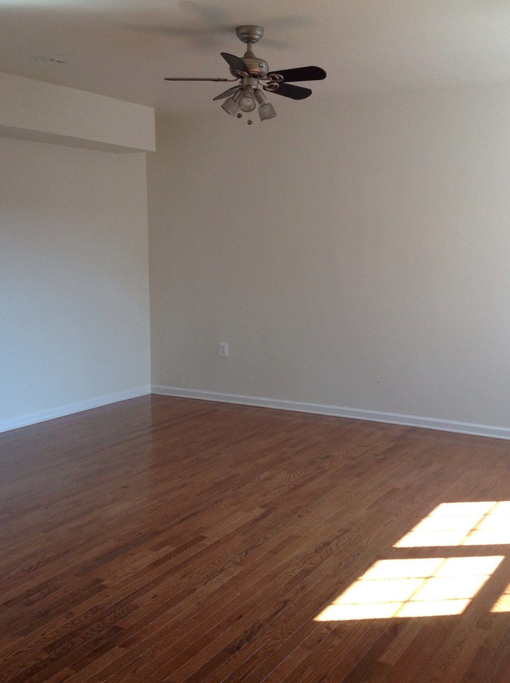 an empty living room with a ceiling fan
