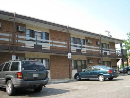 two cars parked in a parking lot in front of a building