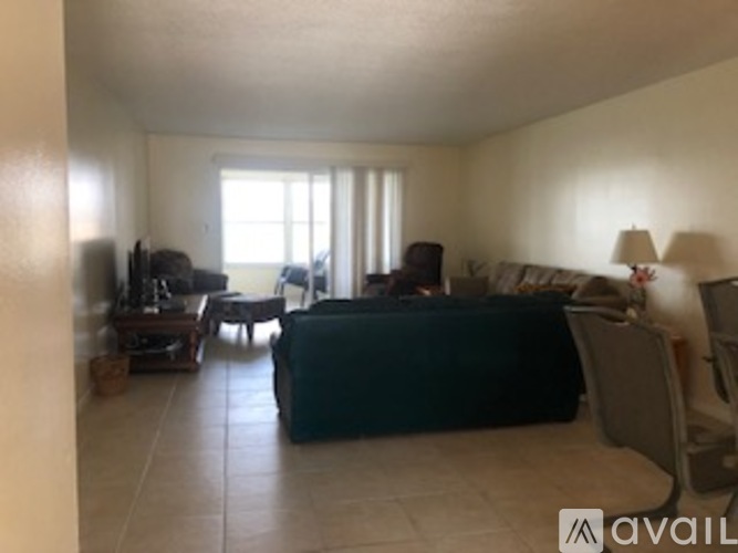 A bedroom with a bed, a couch, a chair, and a table.