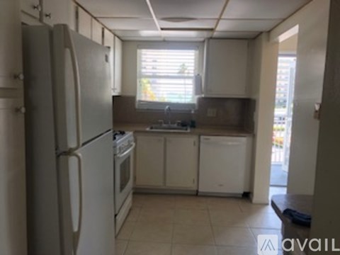 A kitchen with white appliances and cabinets.