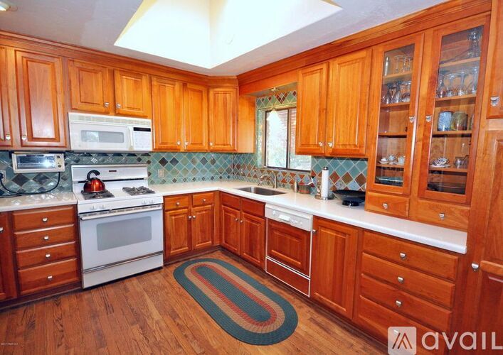 A kitchen with wooden cabinets and a white stove top oven.