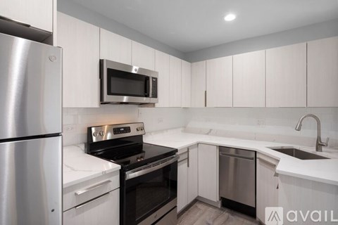 A kitchen with white cabinets and stainless steel appliances.