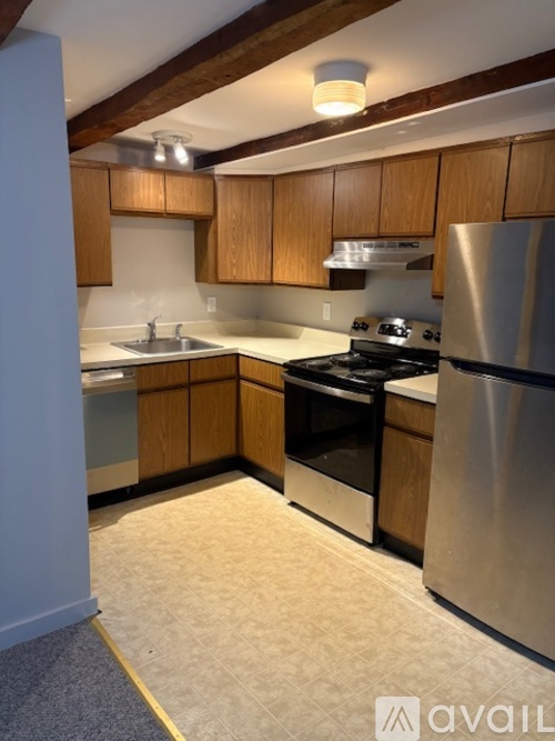 A kitchen with wooden cabinets and stainless steel appliances.