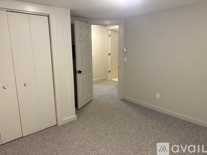 A hallway with a carpeted floor and two doors.