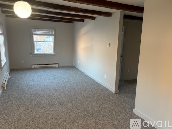 A room with a window and a door is available for rent.