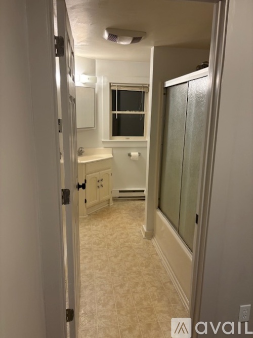 A bathroom with a toilet, sink, and mirror.