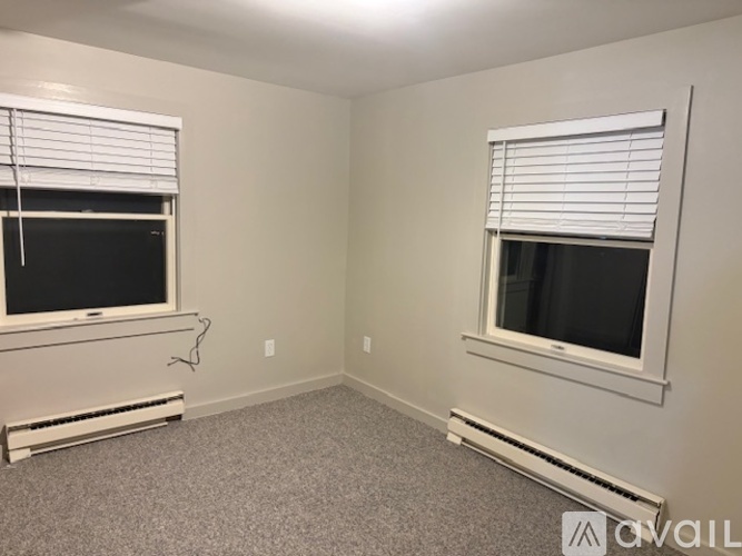 A room with two windows and a carpeted floor.
