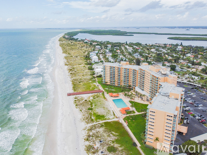 A beachfront hotel with a swimming pool and a view of the ocean.