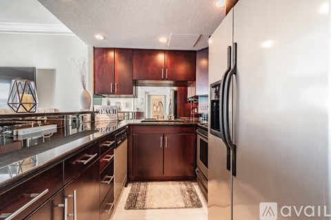 A kitchen with dark wood cabinets and a white fridge.