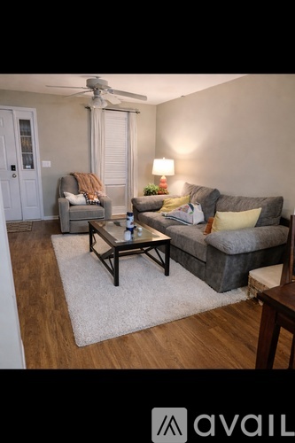 A living room with a wooden floor and a ceiling fan.