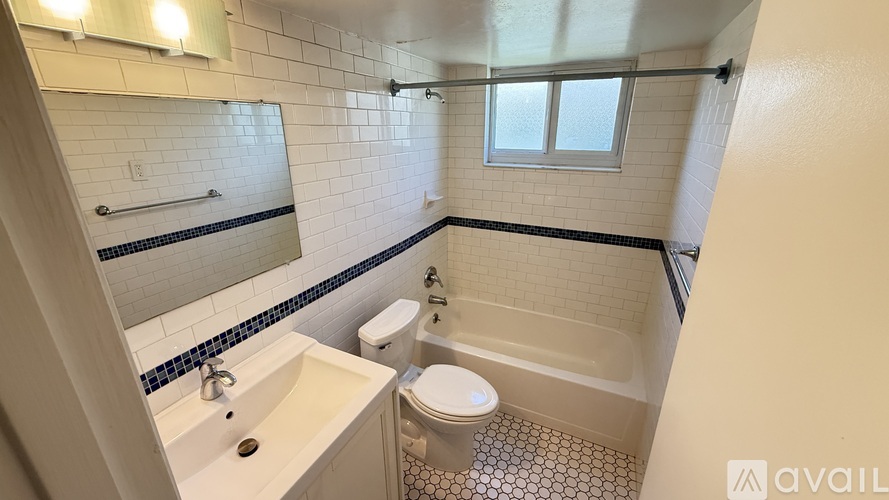 A bathroom with a pink tub, white toilet, and sink.