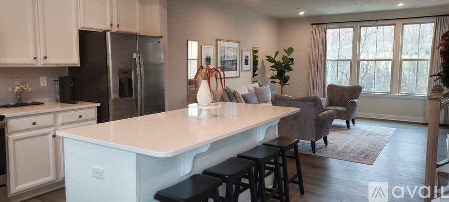 A kitchen with a white island and a refrigerator.