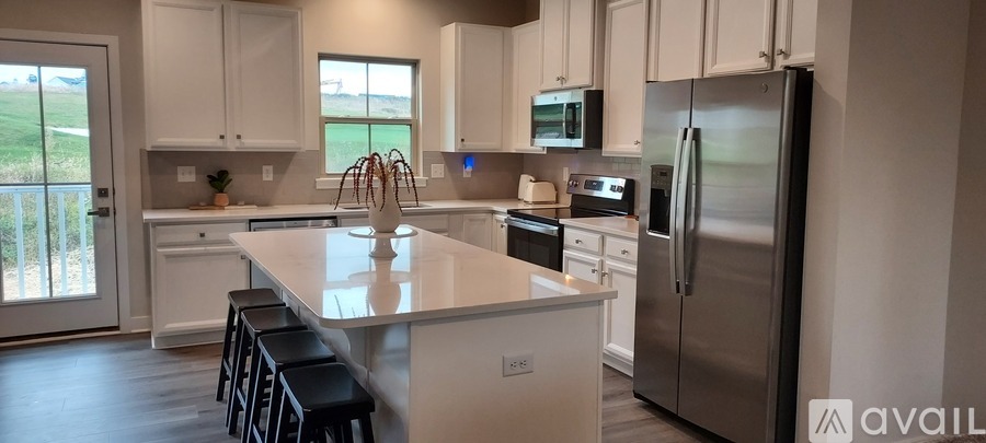 A kitchen with white cabinets and a stainless steel refrigerator.