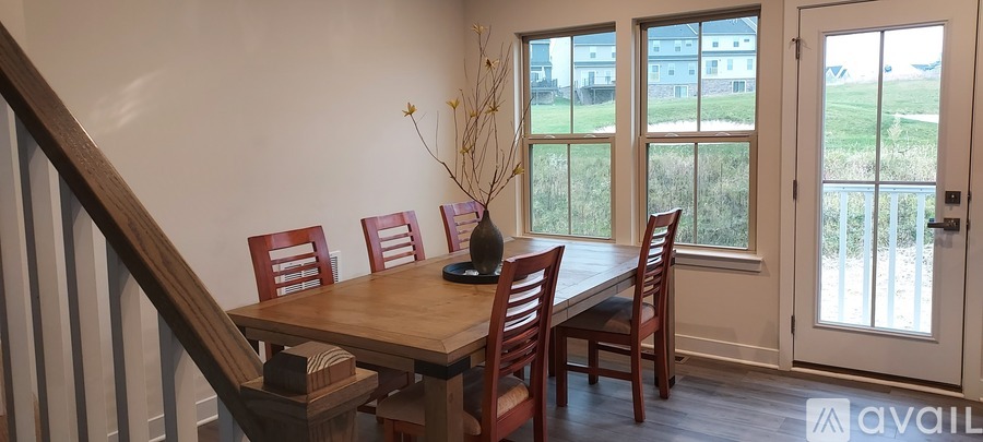 A dining room with a wooden table and chairs.