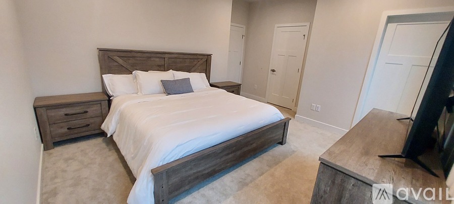 A bedroom with a large bed and a flat screen TV.