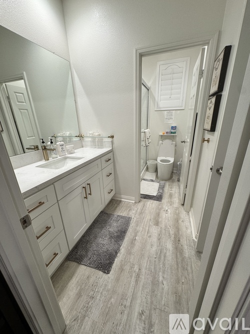 A bathroom with a white sink and a white toilet.