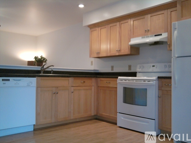 A kitchen with wooden cabinets and white appliances.