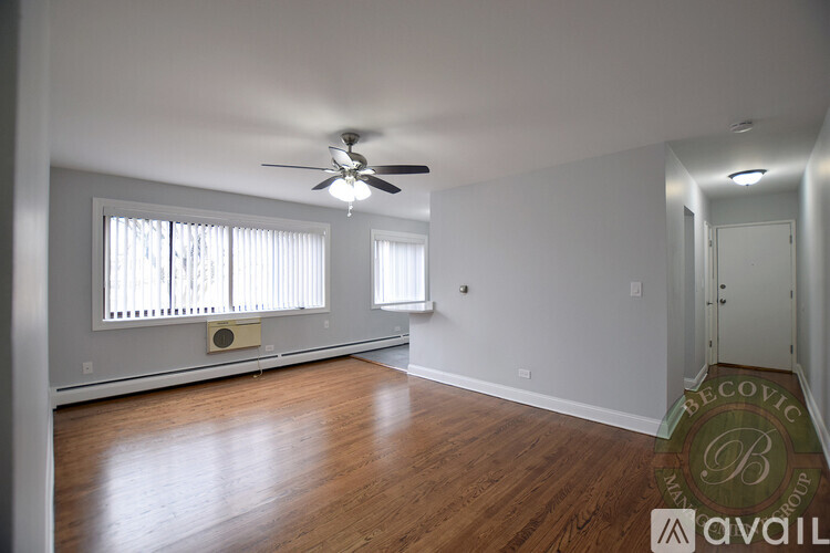 A room with a ceiling fan and wooden floors.