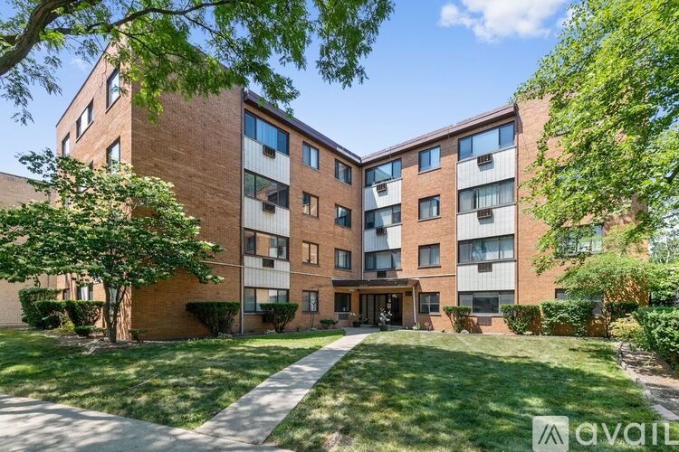 A brick apartment building with a green lawn in front.