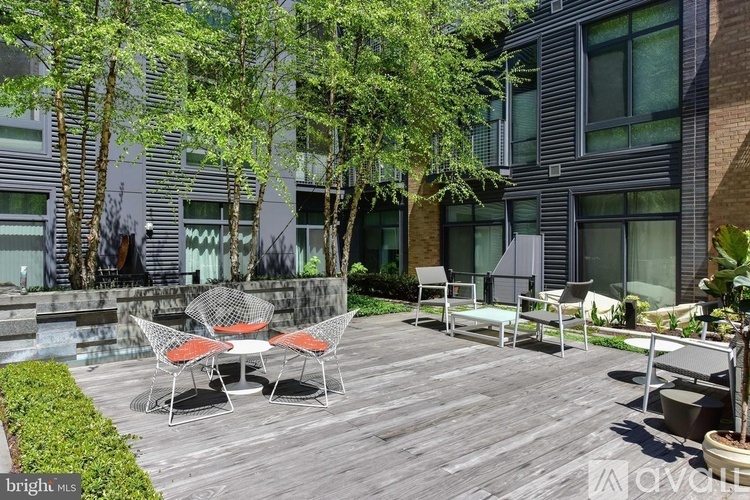 A patio with chairs and a table is in front of a building.