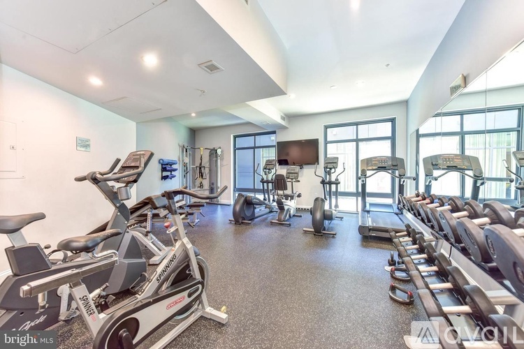 A gym with a row of exercise bikes and a television.