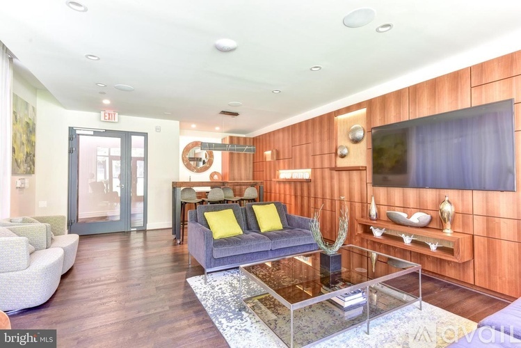 A living room with a grey couch and a glass coffee table.