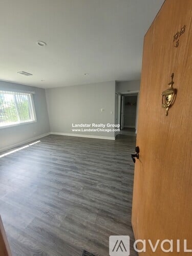 A room with a wooden door and a sign that says "Landstar Realty Group".