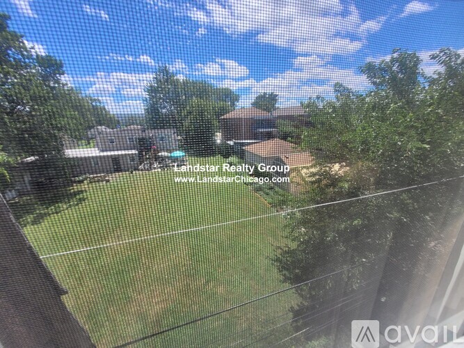 A view of a residential area with houses and trees from a window.