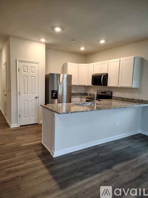 A kitchen with white cabinets and a granite countertop.