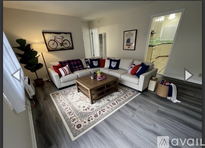 A living room with a white couch and a wooden coffee table.