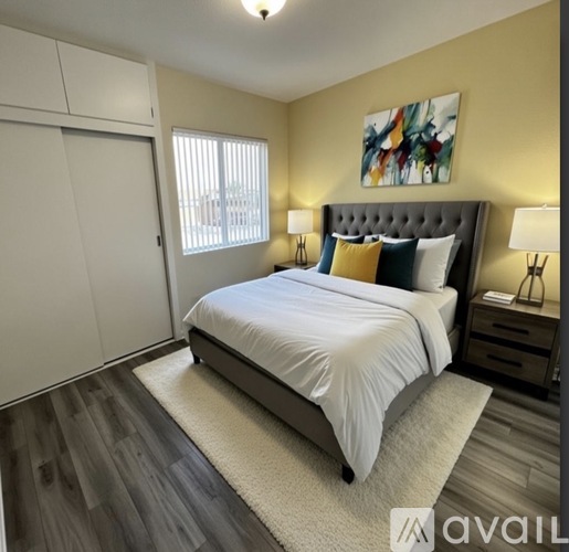 A bedroom with a large bed and a painting on the wall.