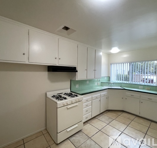A kitchen with white cabinets and a green countertop.