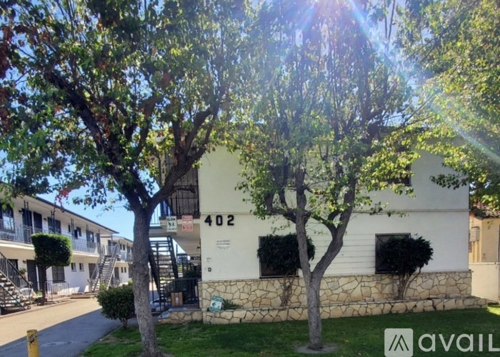 A building with the number 402 on it is surrounded by trees.