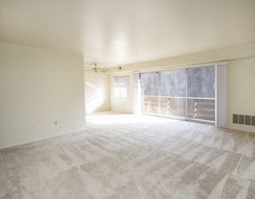 an empty living room with a sliding glass door