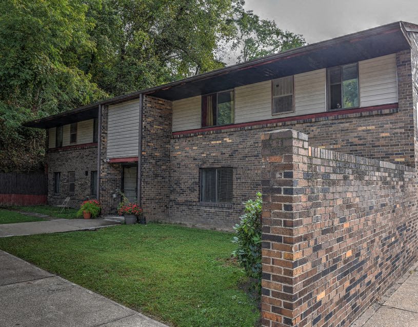 a brick house with a yard in front of it