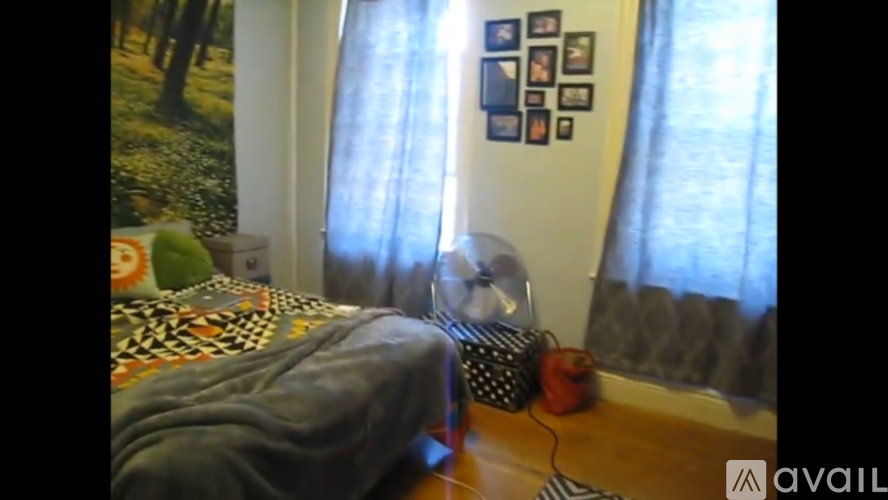 A room with a bed and a wall with pictures on it.