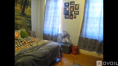 A room with a bed and a wall with pictures on it.