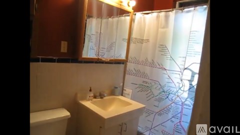 A bathroom with a sink and a map on the shower curtain.