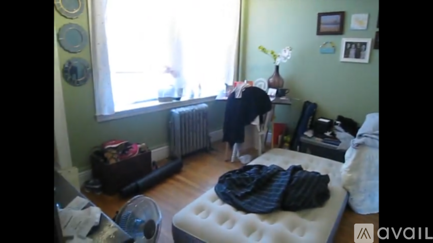 A room with a bed, a radiator, and a window.