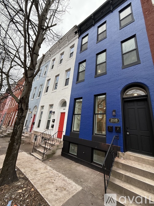 A row of three buildings with the middle one painted blue.