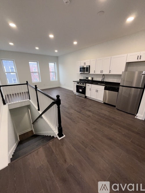 A kitchen with a staircase leading to the upper floor.