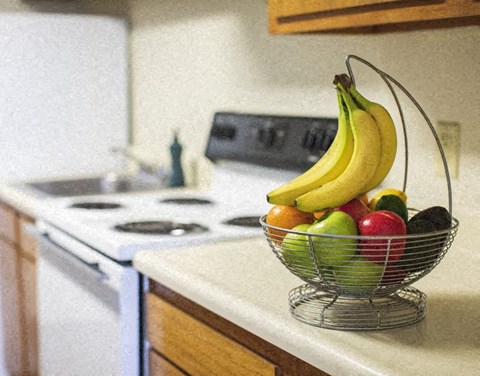 a bowl of fruit sitting on a kitchen counter
