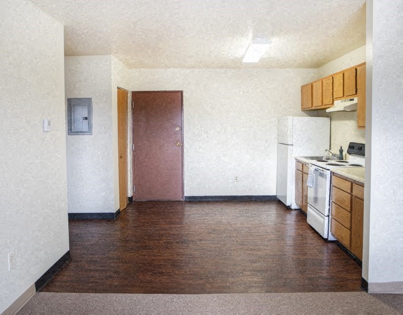 an empty kitchen with a stove and a refrigerator