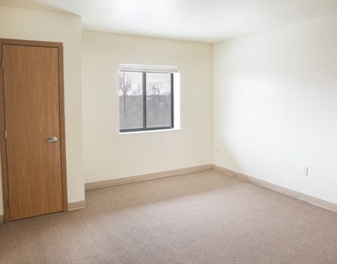 an empty room with a window and a door