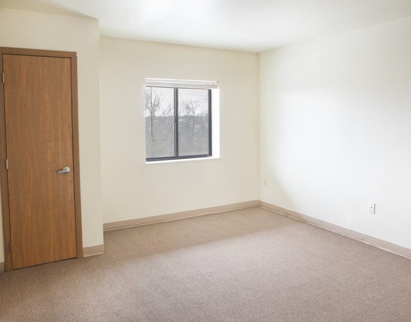 an empty room with a window and a door