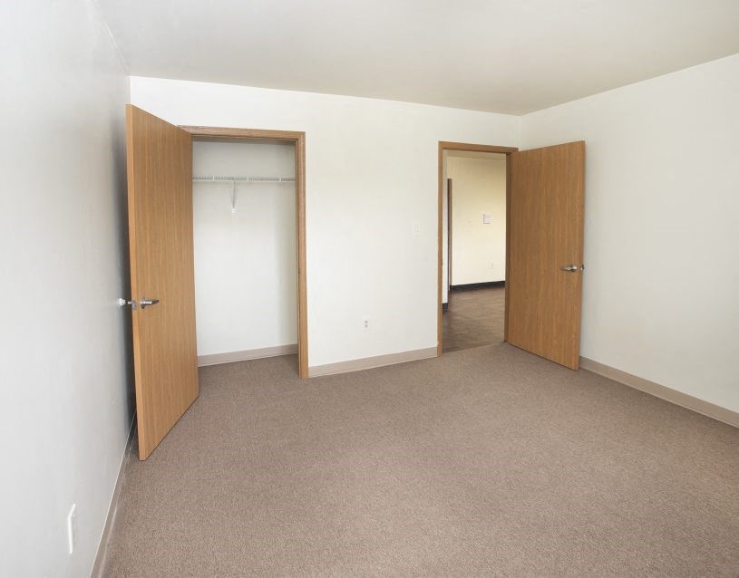 a empty room with two doors and a closet