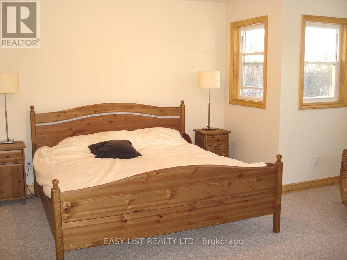 A bedroom with a large bed and two nightstands.